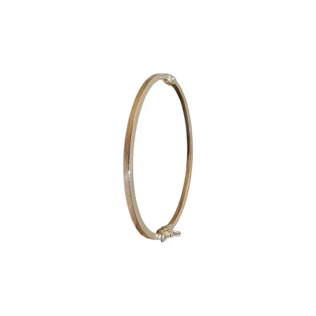 Een gouden armband met een diamant in het midden op een witte achtergrond