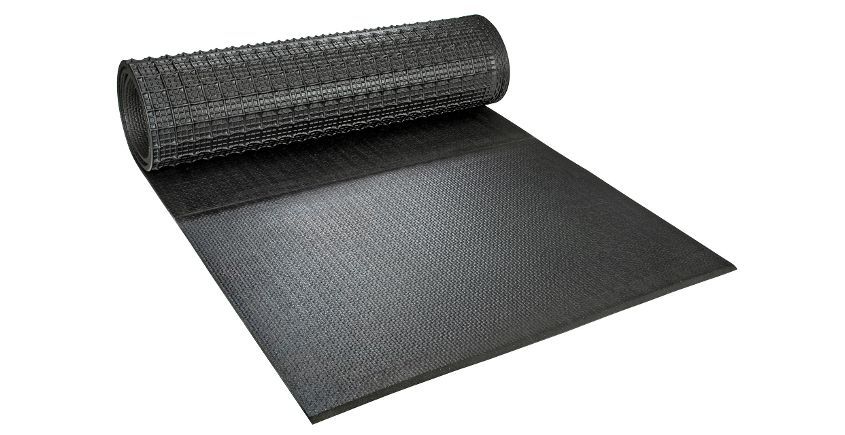 Rouleau noir de tissu d'aménagement paysager texturé partiellement déroulé sur une surface blanche.