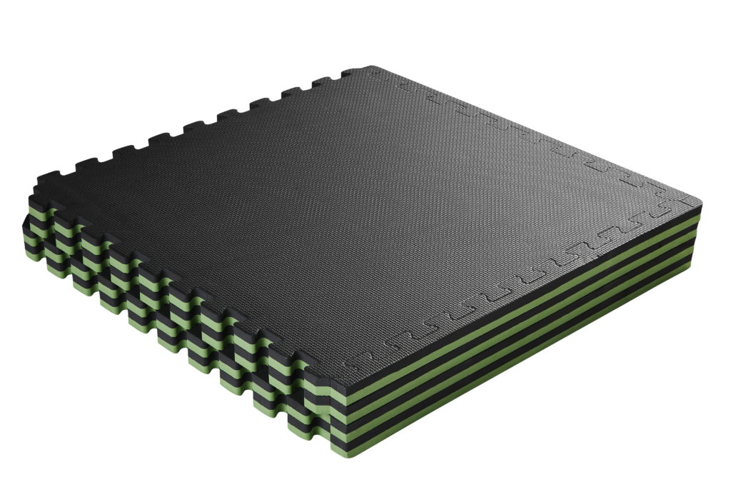 Empilement de tapis en mousse noire et verte à surface texturée, représenté en perspective sur fond blanc.