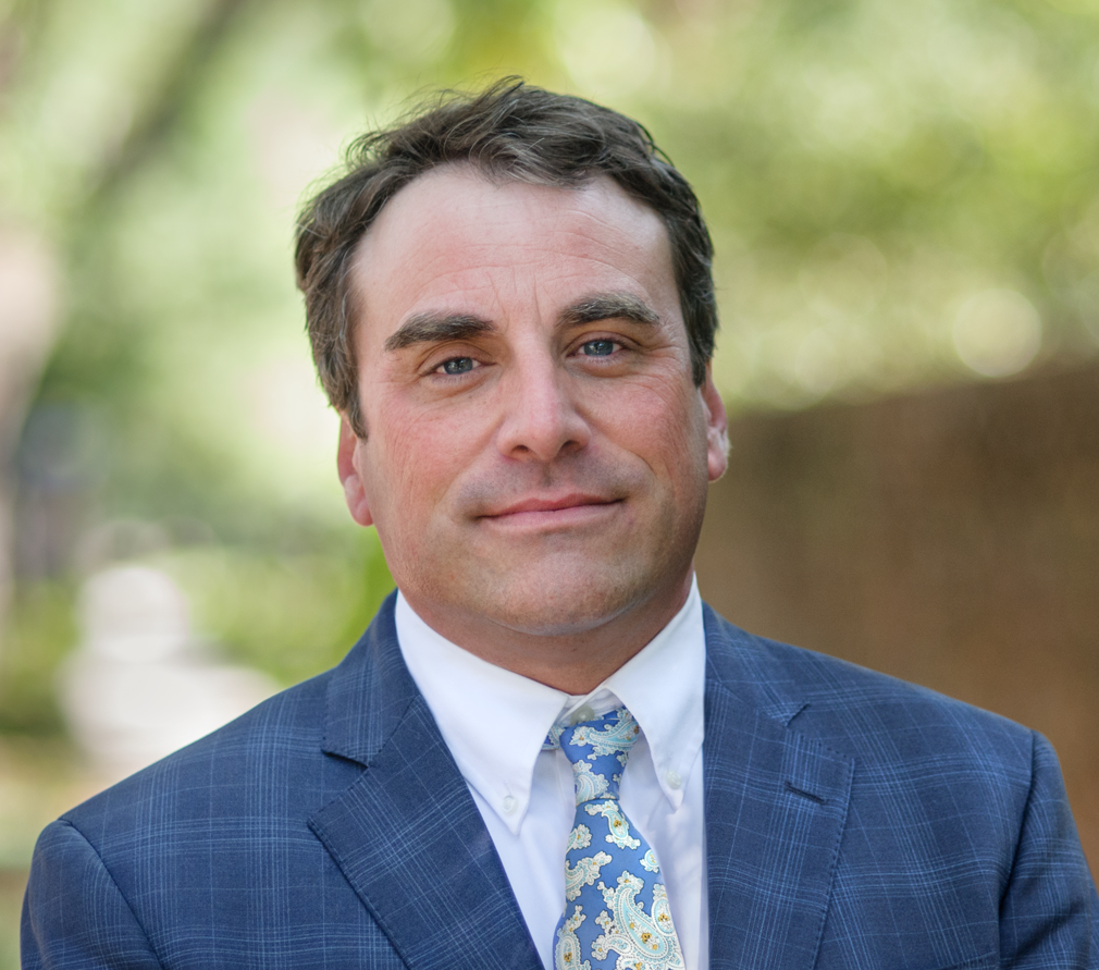 A man in a suit and tie is smiling for the camera.