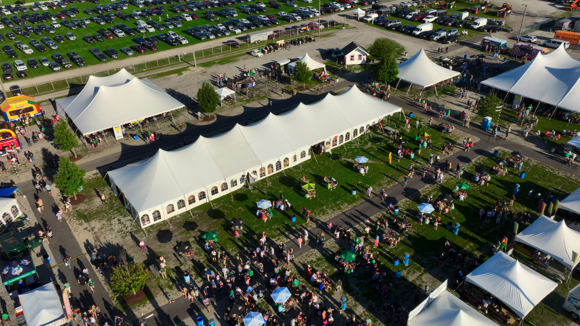 A large black inflatable tent is sitting on top of a lush green field.