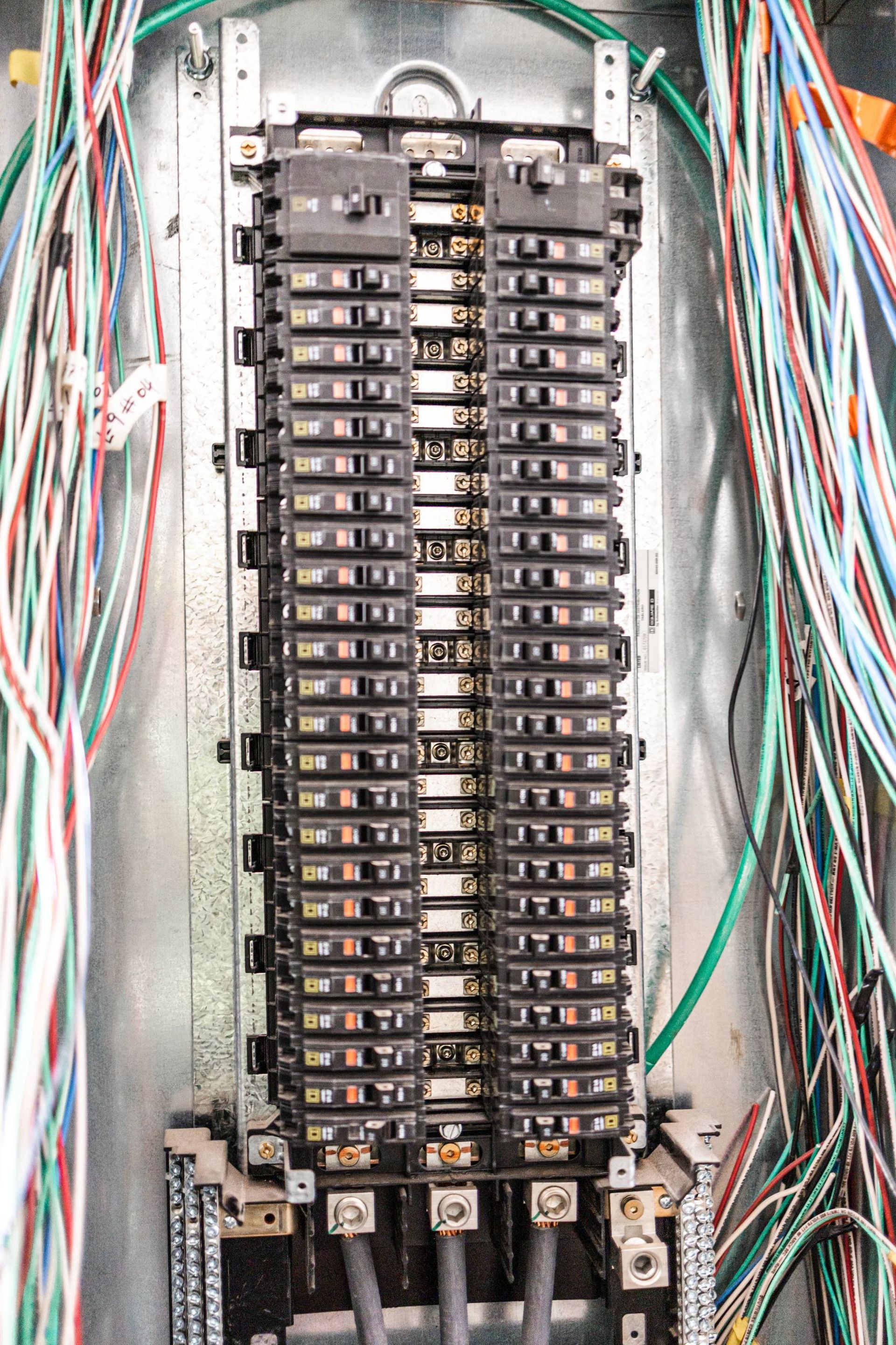 Electrical panel with numerous circuit breakers and wires.