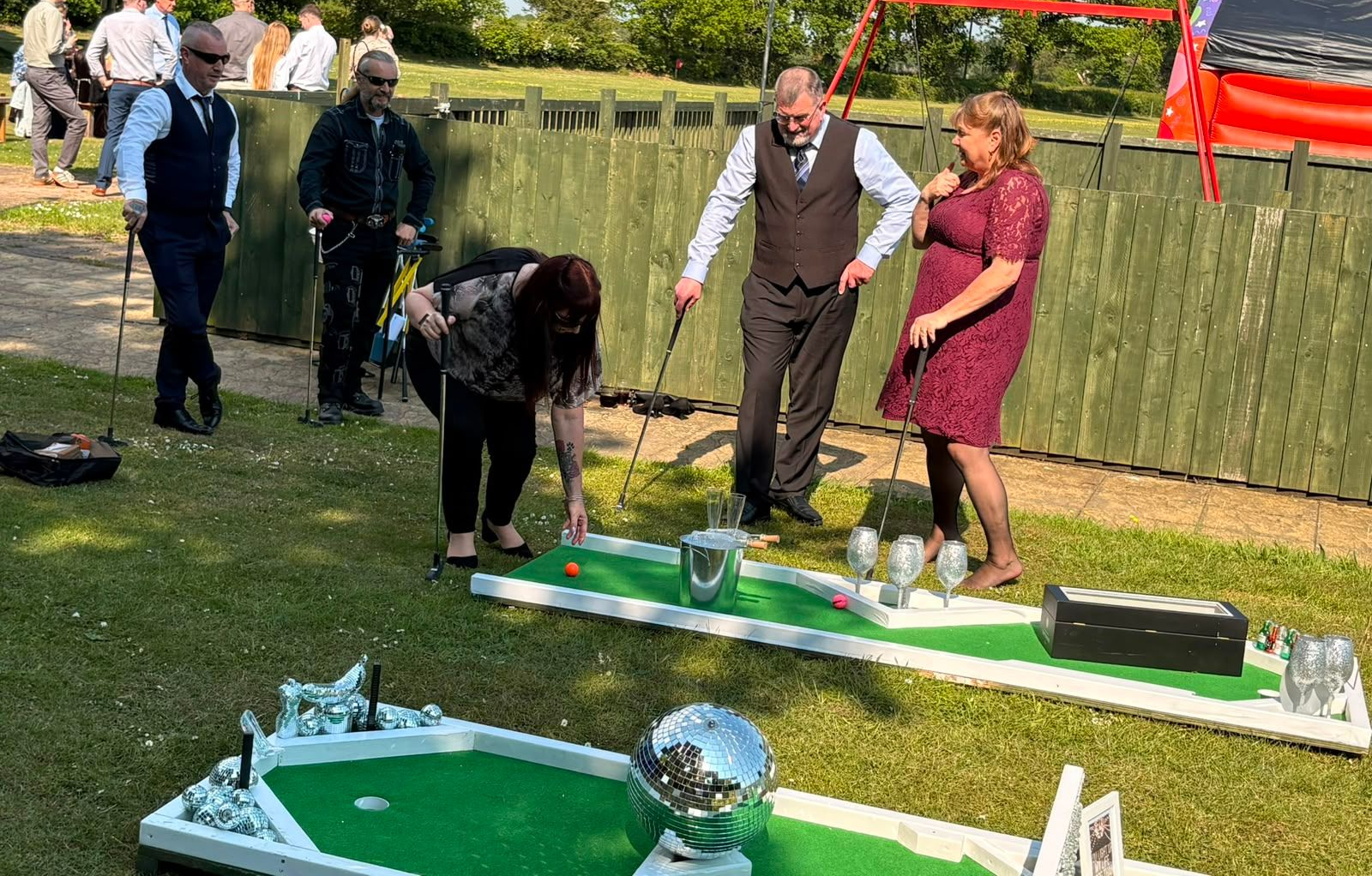Guests gathered around a mini golf hole at a party