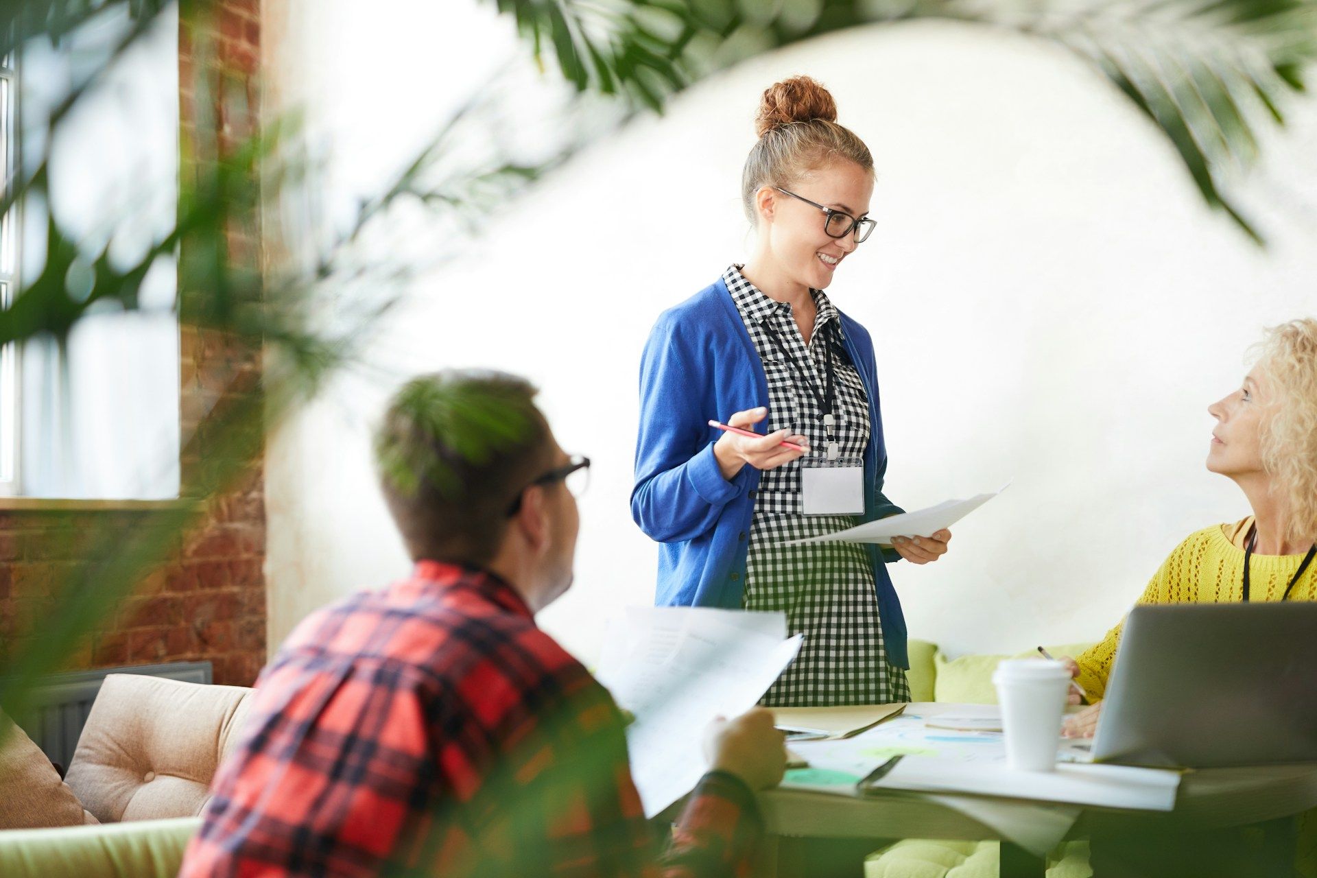 A woman is giving a presentation to a group of people in an office.