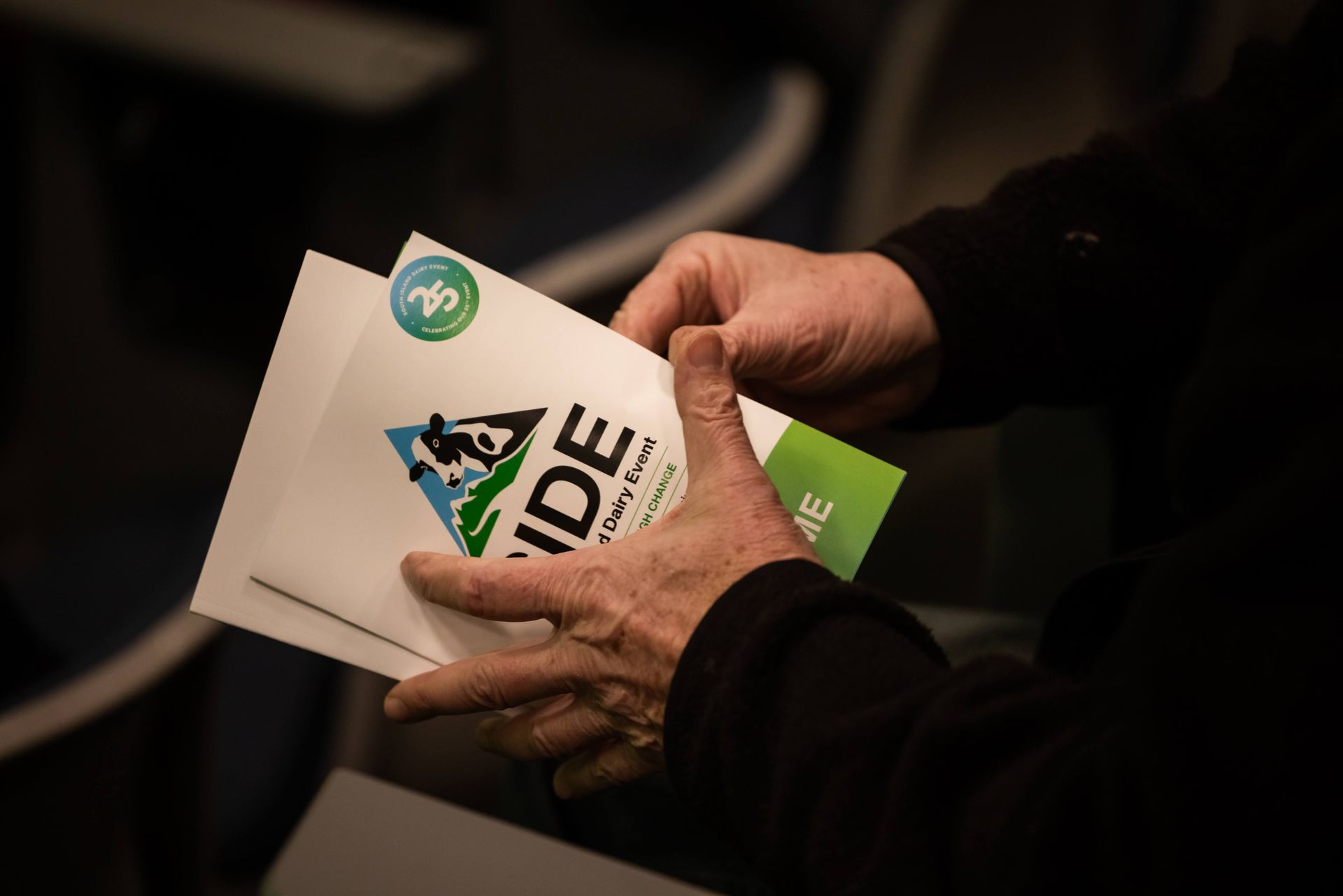 Hands holding papers for an event called