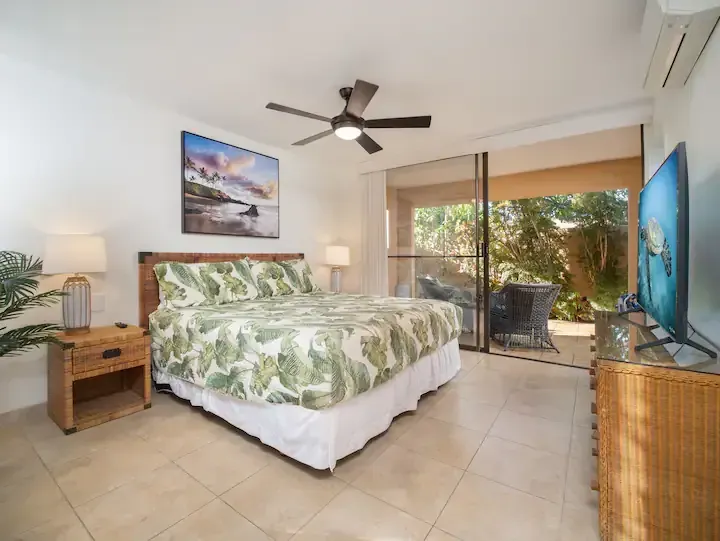 A bedroom with a king size bed and a flat screen tv.