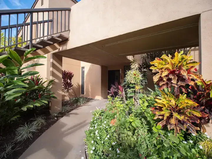 A walkway leading to a house with a balcony