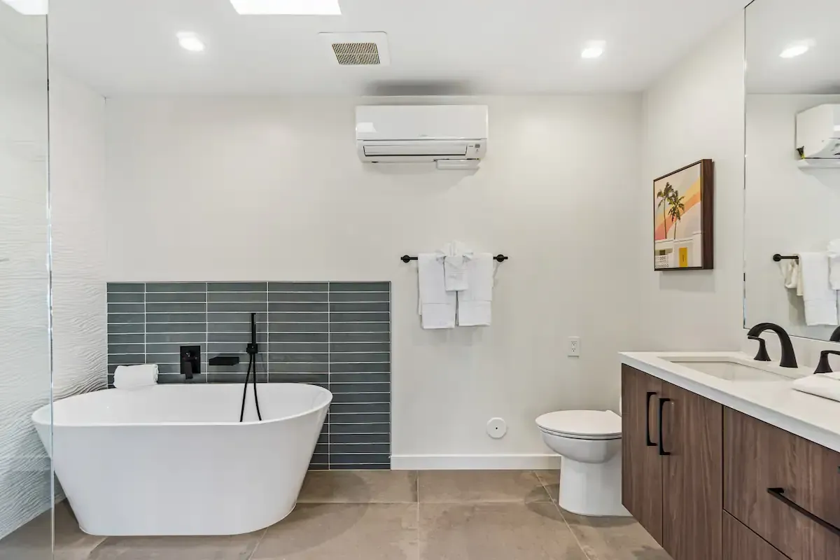 A bathroom with a bathtub , toilet , sink and mirror.