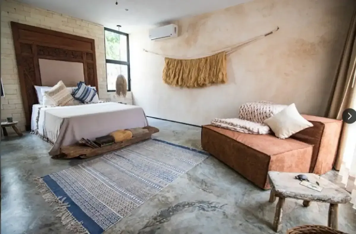 A bedroom with a bed , couch , and rug.