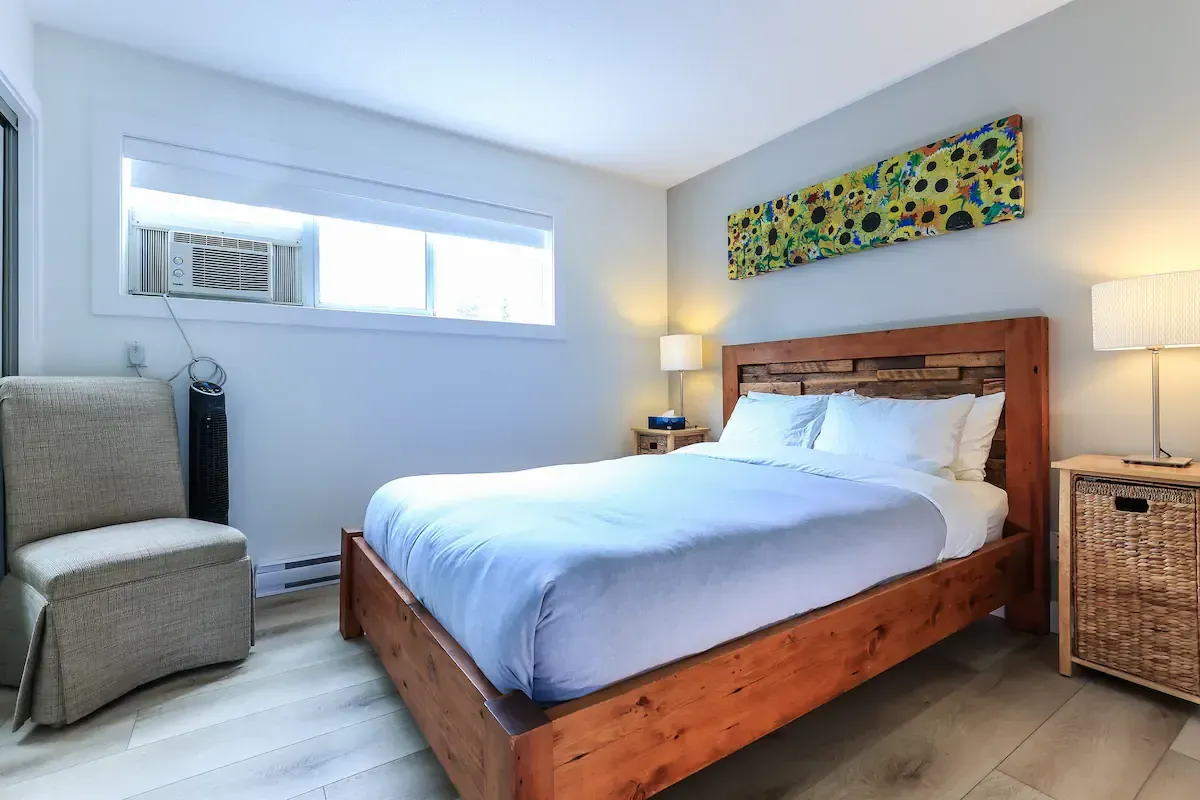 A bedroom with a large bed and a chair