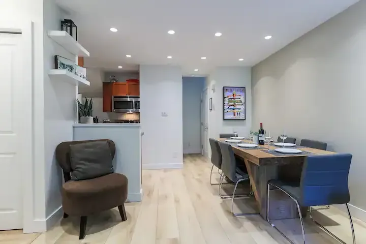 A living room with a dining table and chairs and a chair.