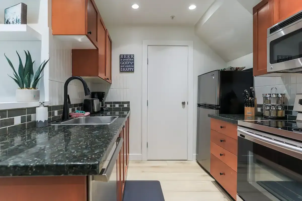 A kitchen with stainless steel appliances and granite counter tops.