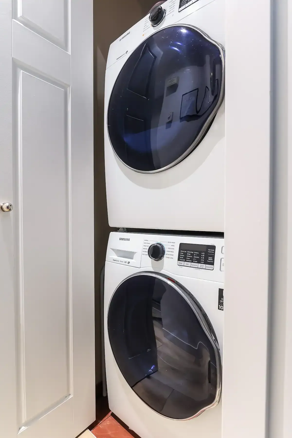 A washer and dryer are stacked on top of each other in a laundry room.