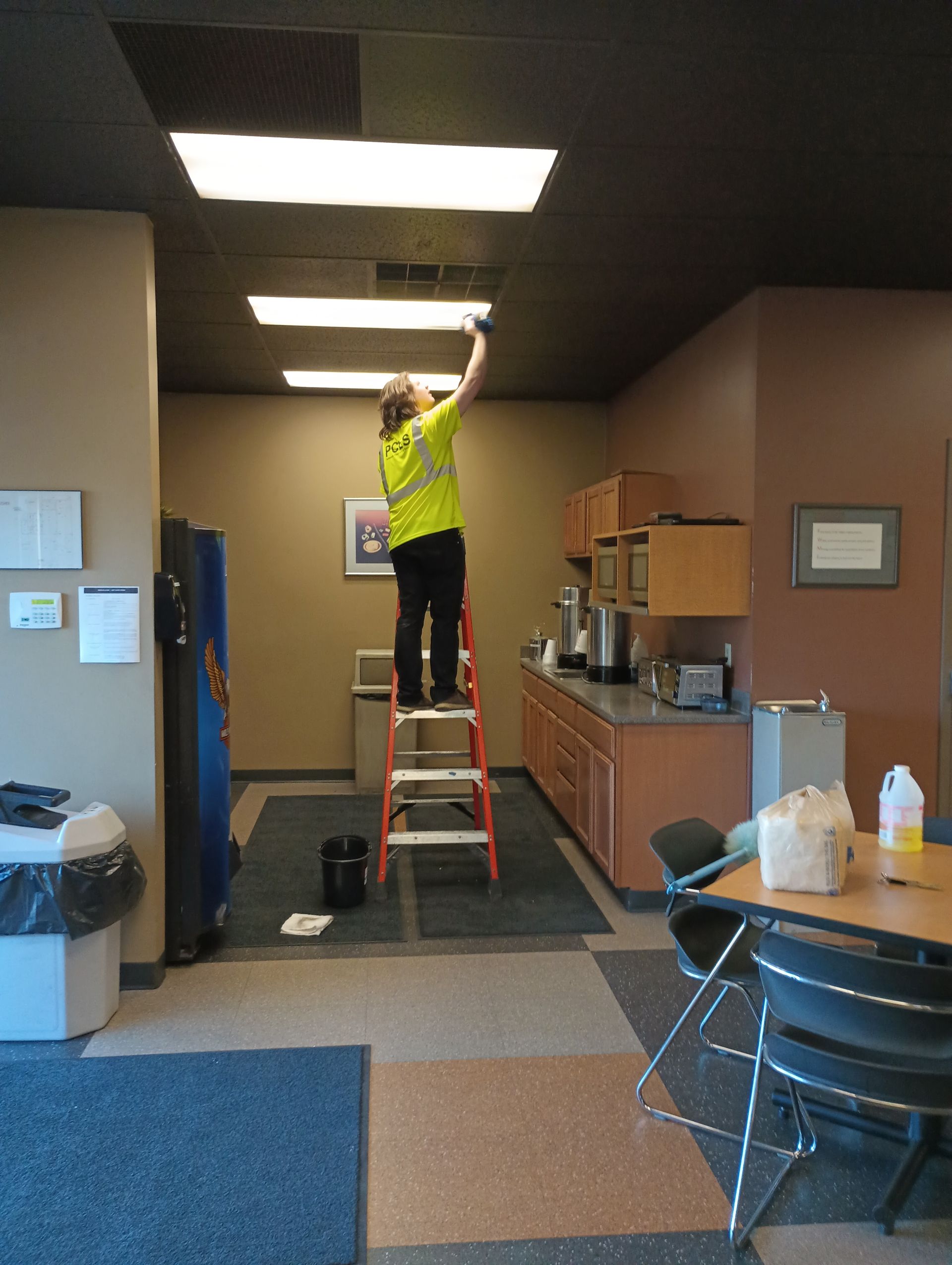 janitor dusting lights