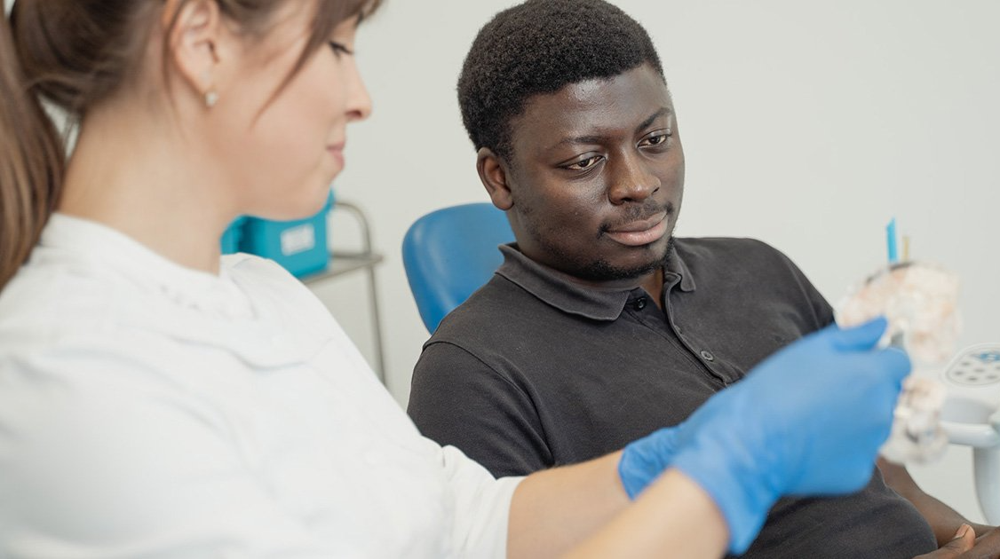 Dentist helping Male patient at Sewell