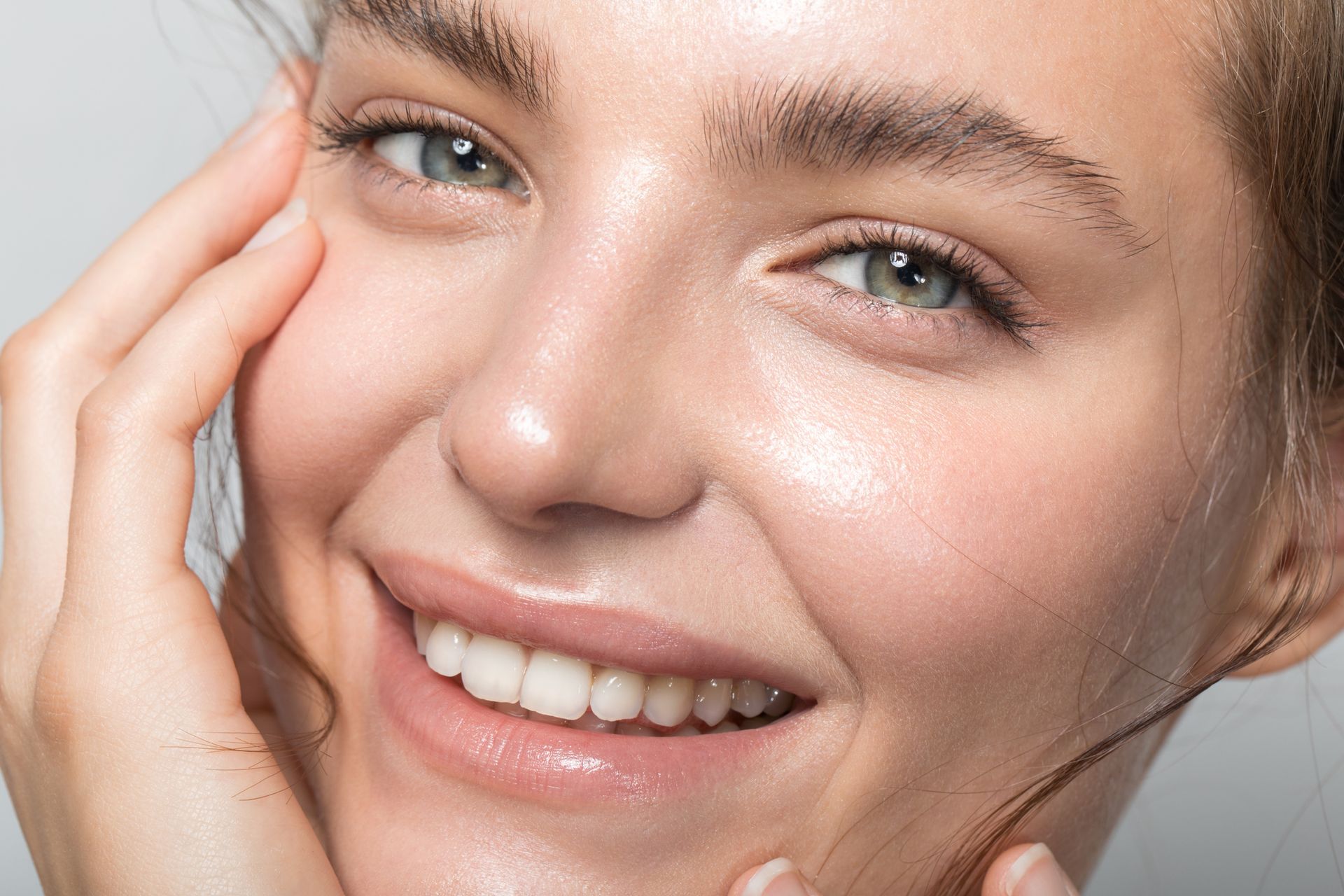A close up of a woman 's face with a smile on her face. A close up of a woman 's face with a smile on her face.