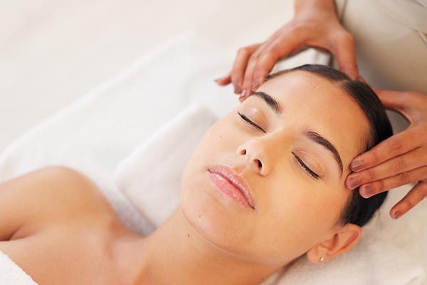 A woman is getting a head massage at a spa.