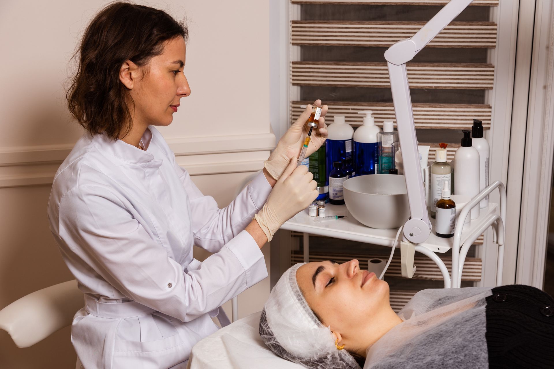 A woman is giving a woman a facial treatment in a beauty salon. A woman is giving a woman a facial treatment in a beauty salon.
