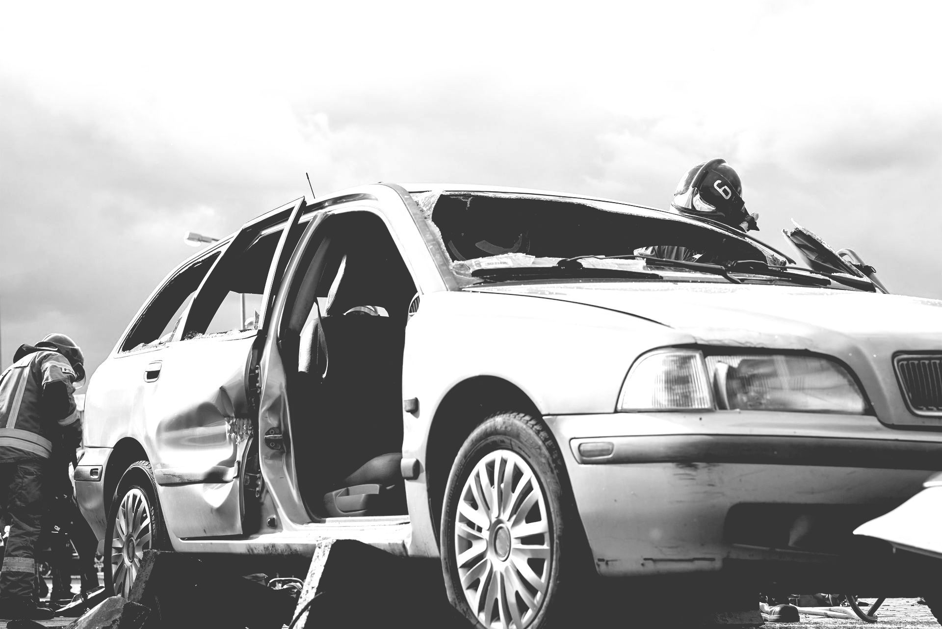 Damaged white SUV on a tow truck, with responders working beside it.