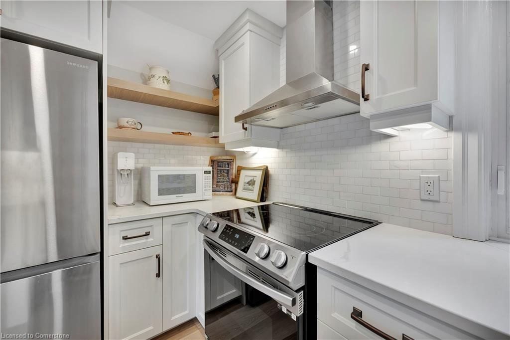 Small white kitchen with stainless steel appliances, white cabinets, and a gas stove.