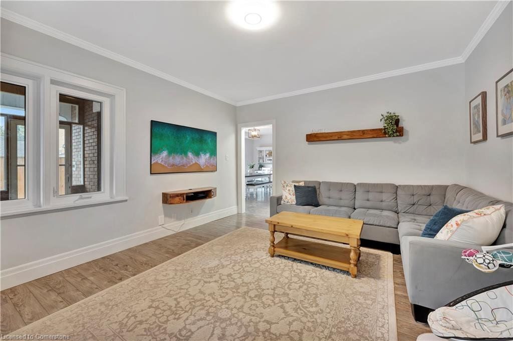 Living room with gray walls, sectional sofa, wooden coffee table, and an area rug.