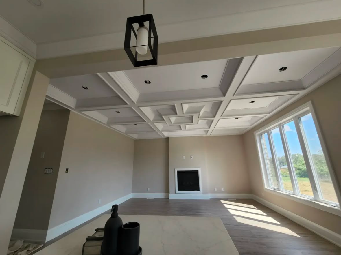 Empty room with decorative ceiling, fireplace, and large windows.