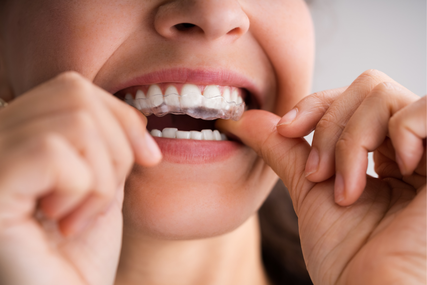 Close-up of a person flossing white teeth with both hands