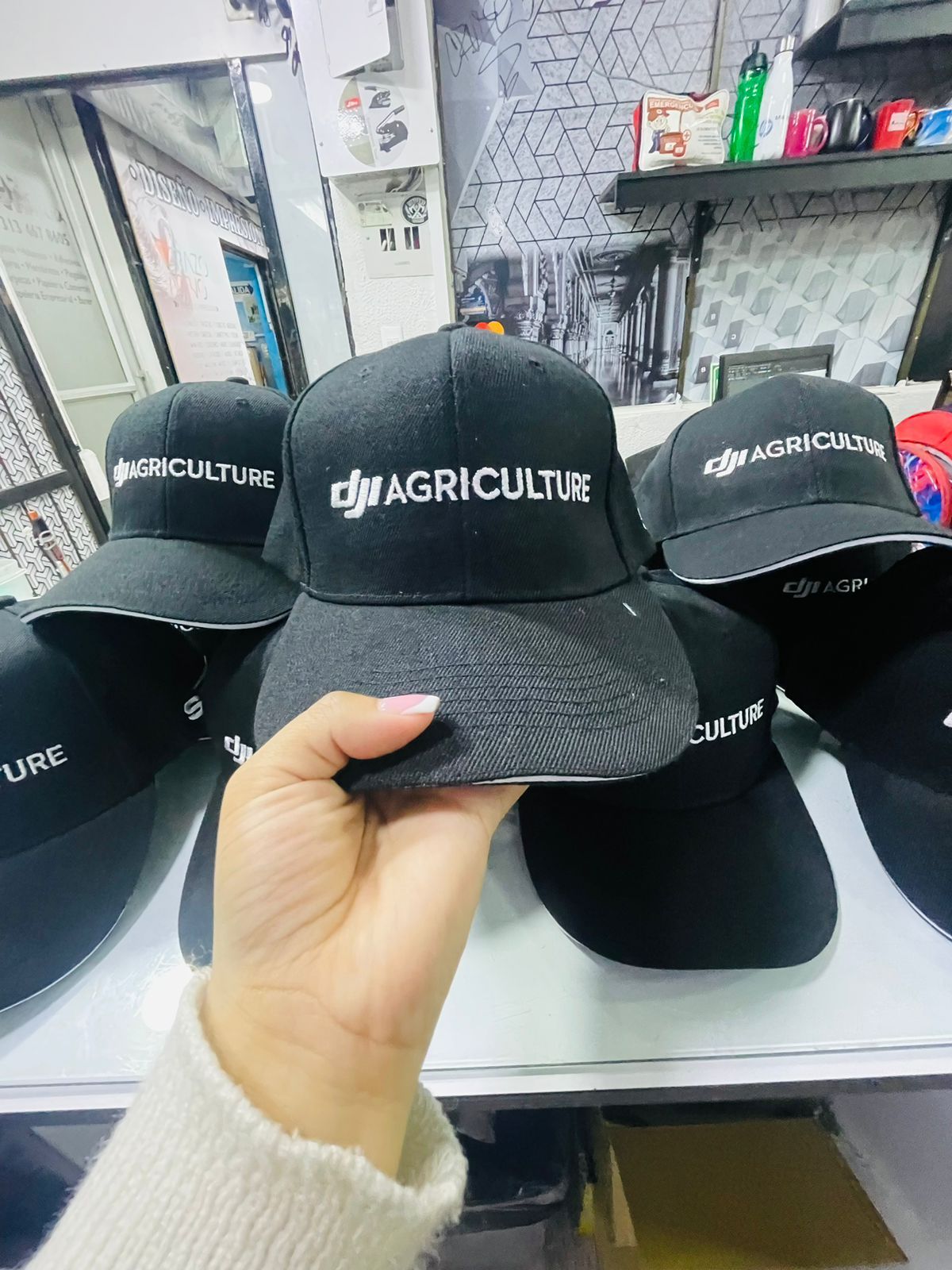 Mano sosteniendo una gorra negra con la inscripción