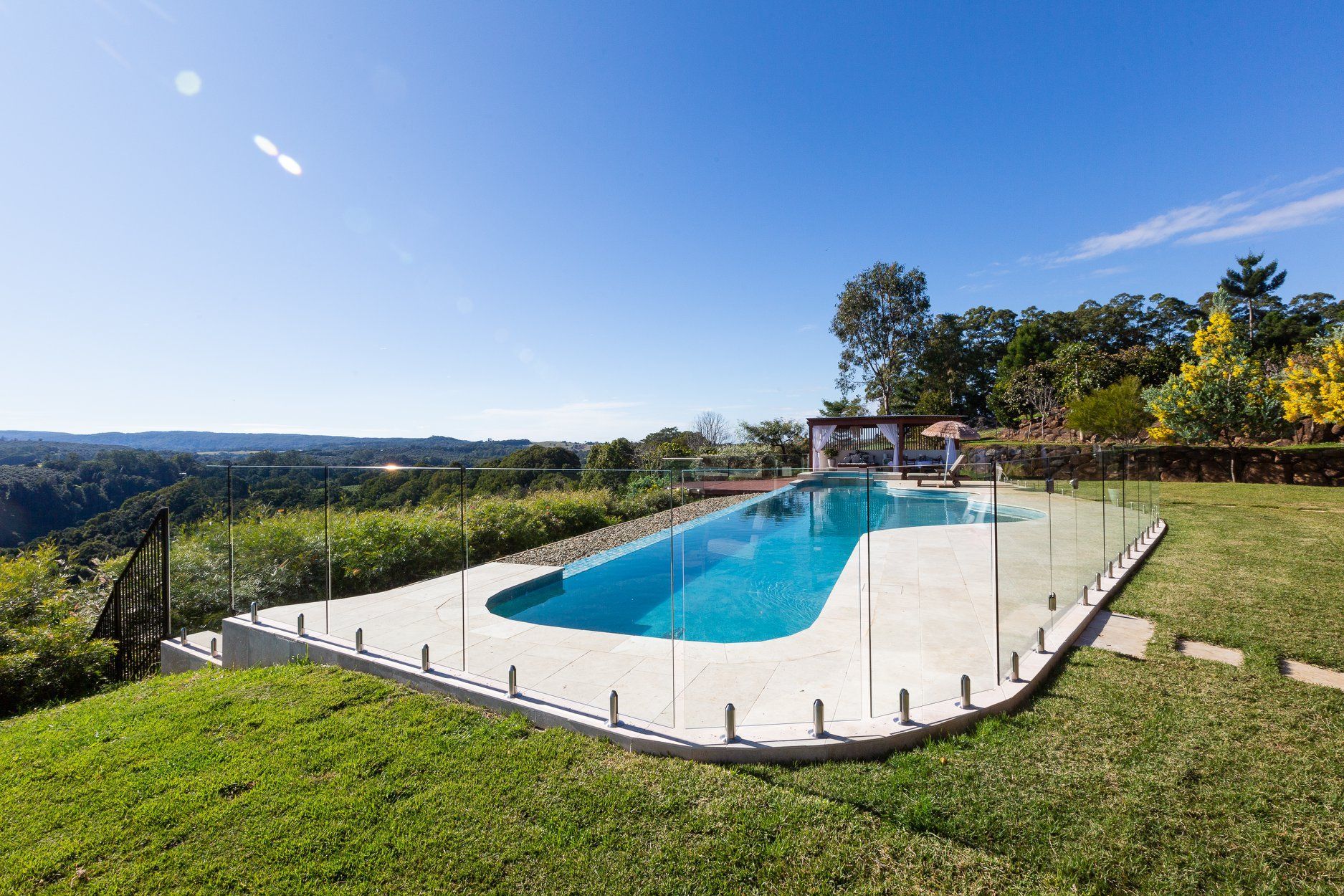 There is a large Swimming pool in the Middle of a lush Green field — Profile Pools & Landscaping In Byron Bay, NSW