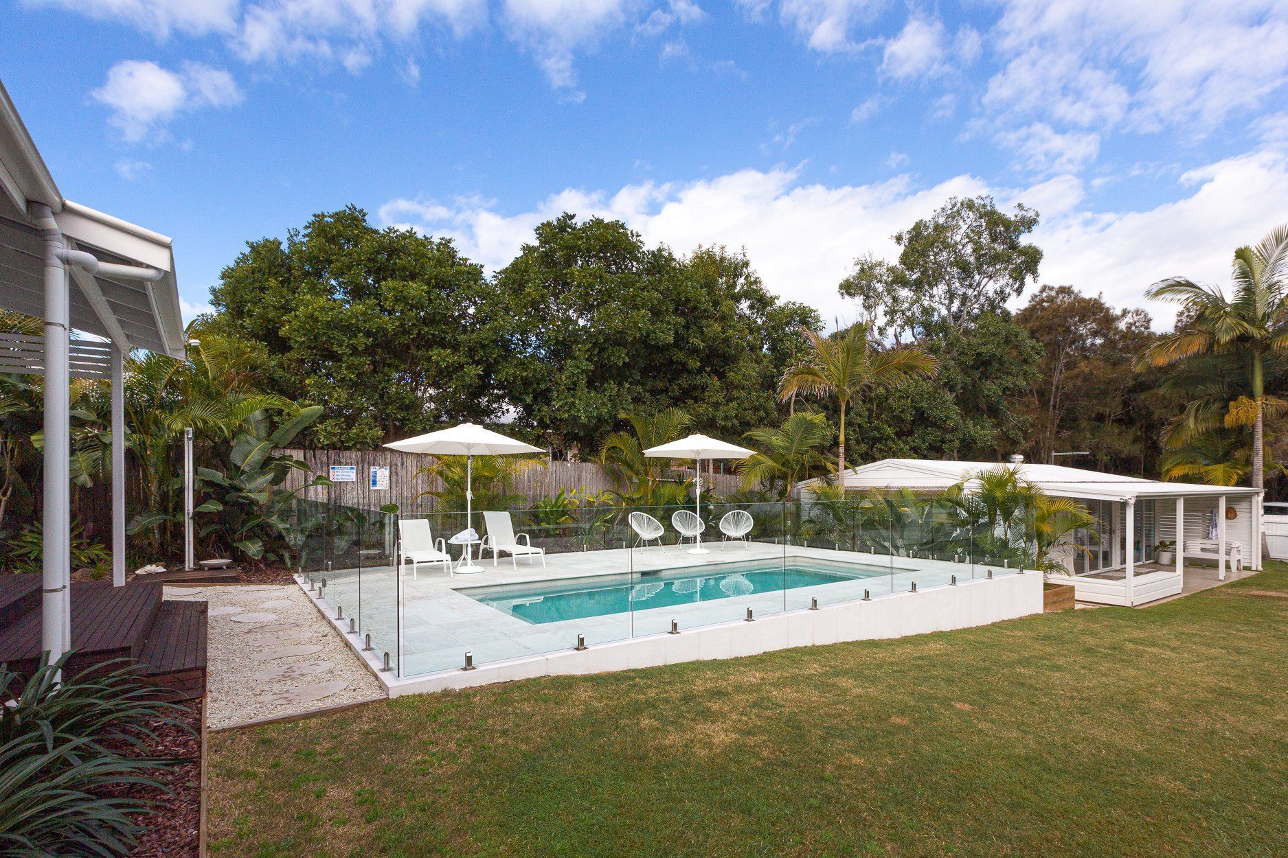 There is a Large Swimming pool in the Backyard of a House — Profile Pools & Landscaping In Byron Bay, NSW