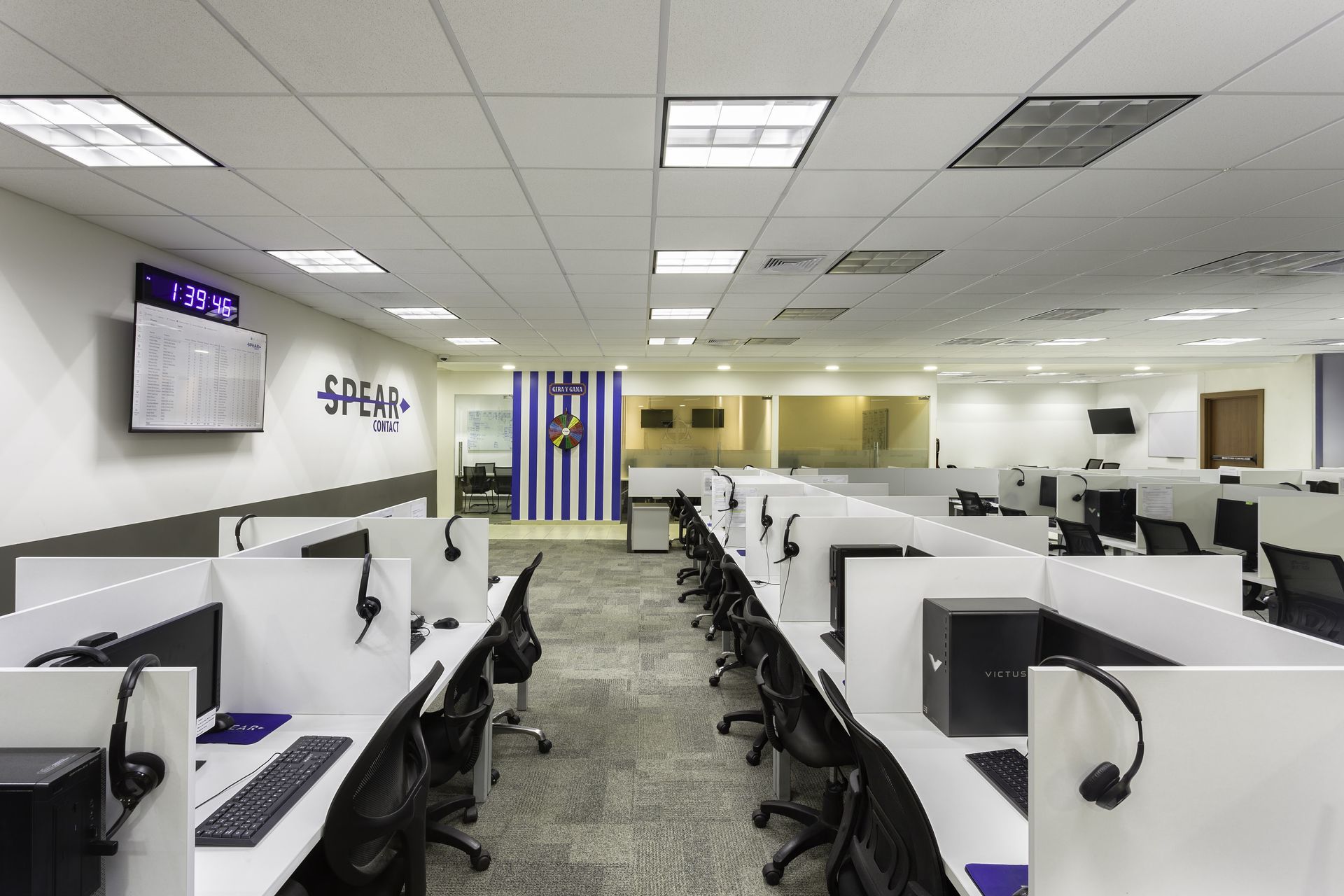 Una oficina grande con muchos cubículos y computadoras.