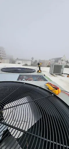 Rooftop HVAC units on a foggy city skyline, with a yellow toy car in the foreground.