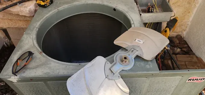 Open HVAC unit with a large circular opening and exposed interior parts on a rooftop