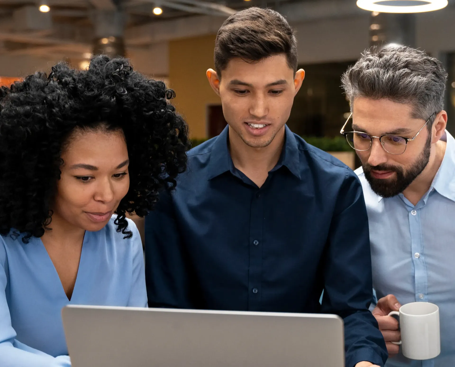 A group of people are looking at a laptop computer.