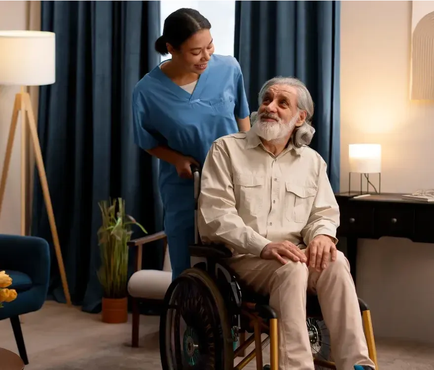 An elderly man in a wheelchair is being helped by a nurse.