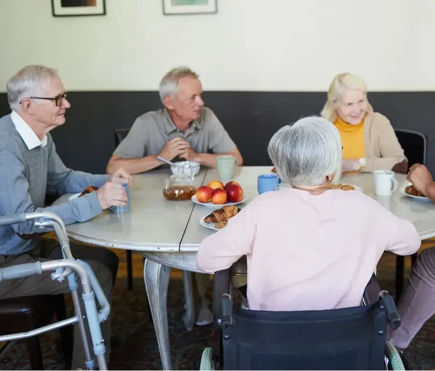 A group of people are sitting around a table with food on it