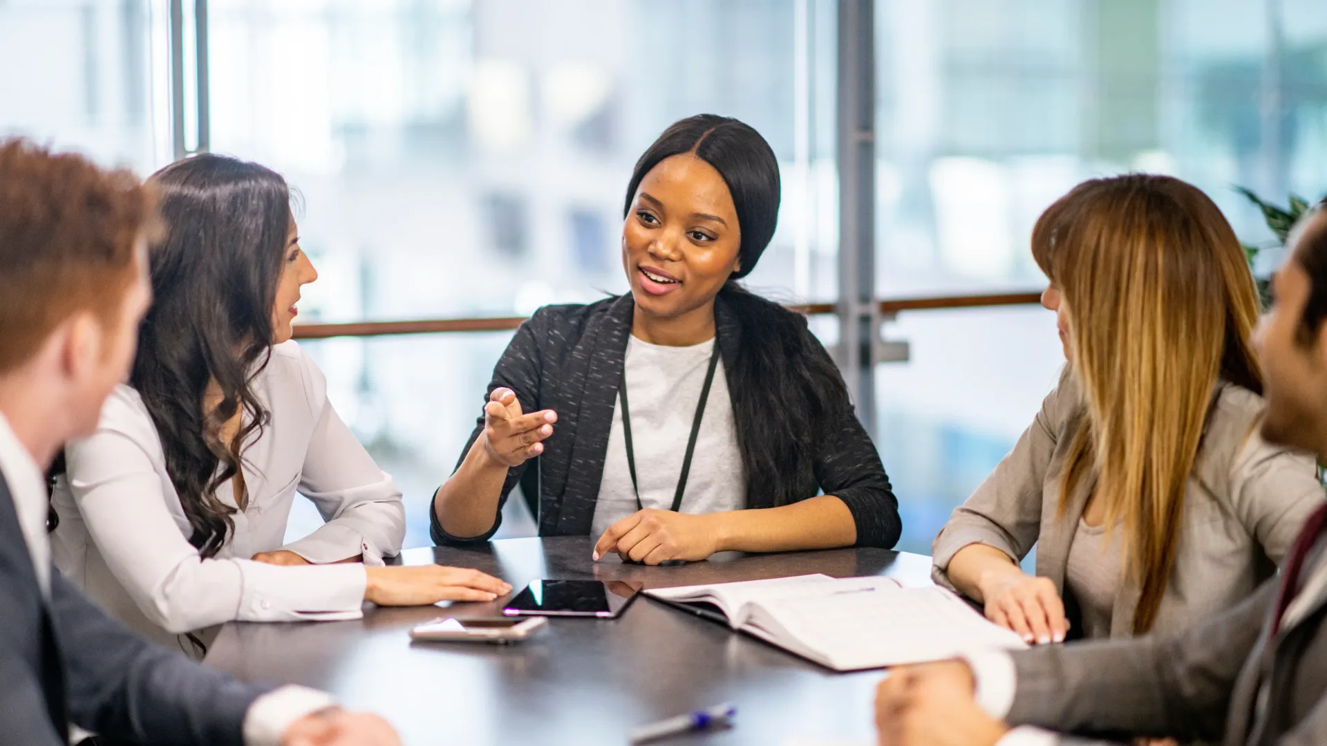 A group of people are sitting around a table having a meeting.