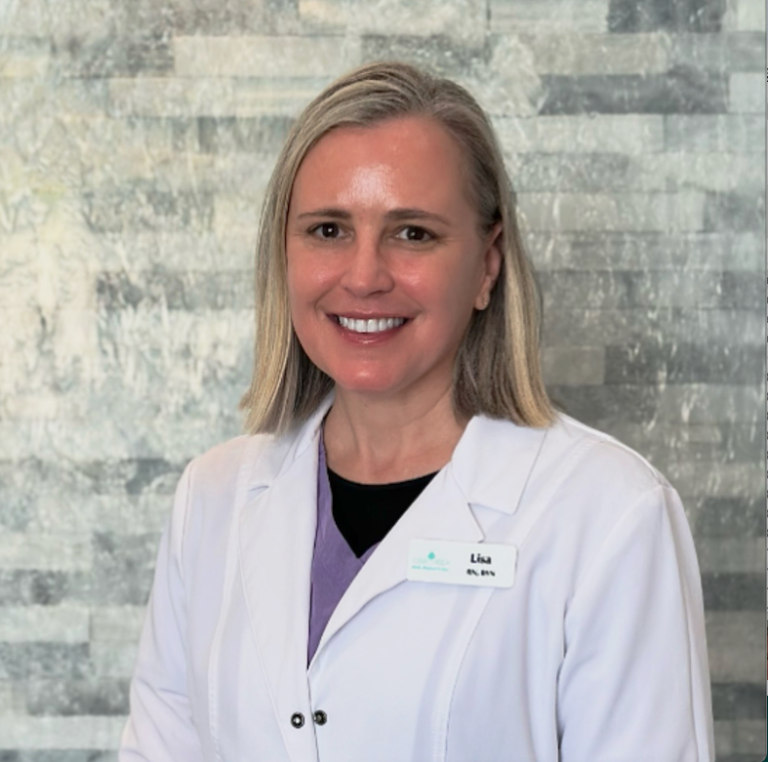 Smiling doctor in white coat standing before a textured gray wall