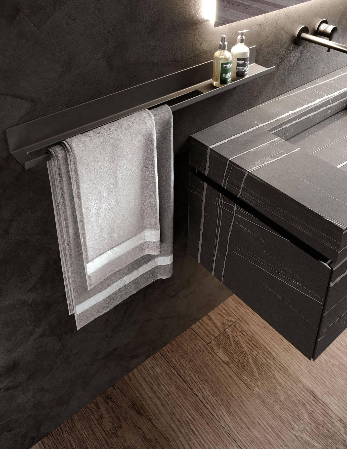 Interno del bagno con asciugamano grigio appeso a una barra di metallo scuro. Pavimento in legno, mobile lavabo scuro.