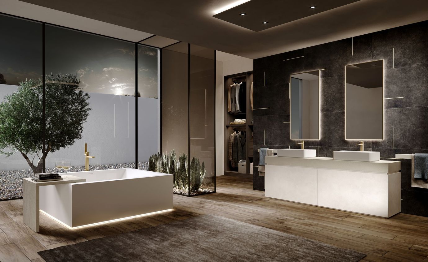 Moderna vasca da bagno quadrata bianca con rubinetto dorato, tavolino laterale e illuminazione sottostante.