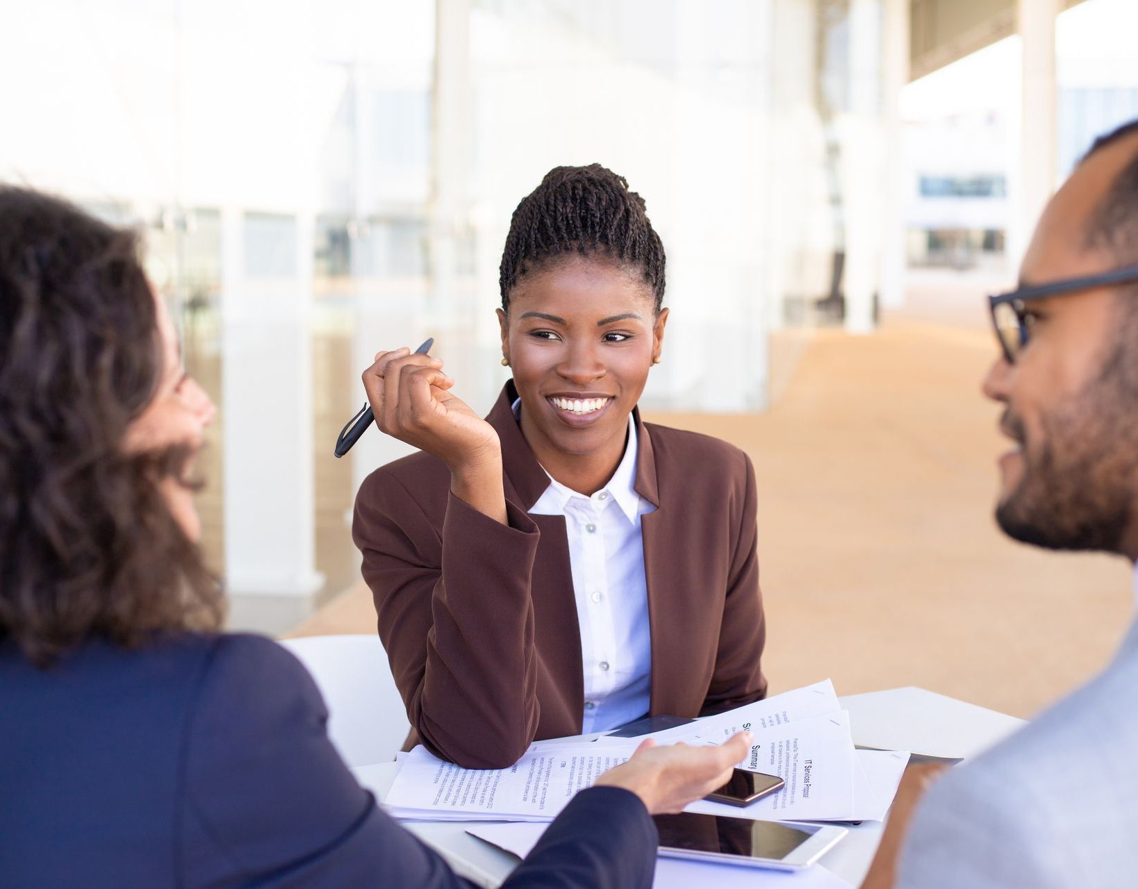 A woman is smiling while shaking hands with a man