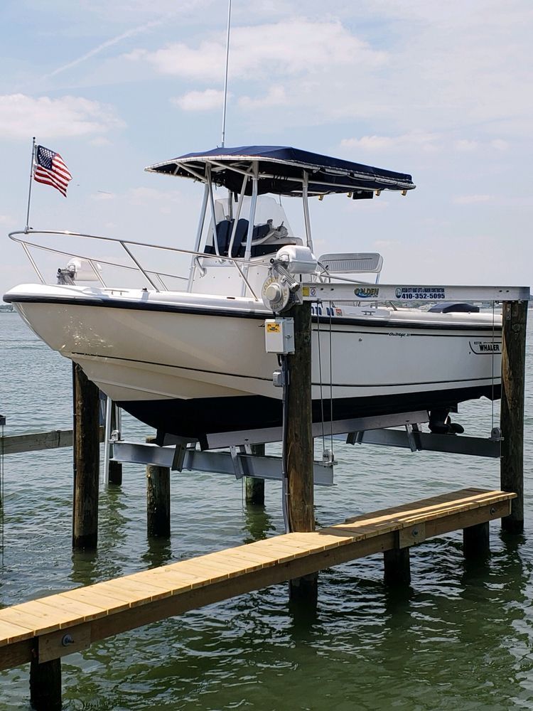 A boat is sitting on a lift in the water