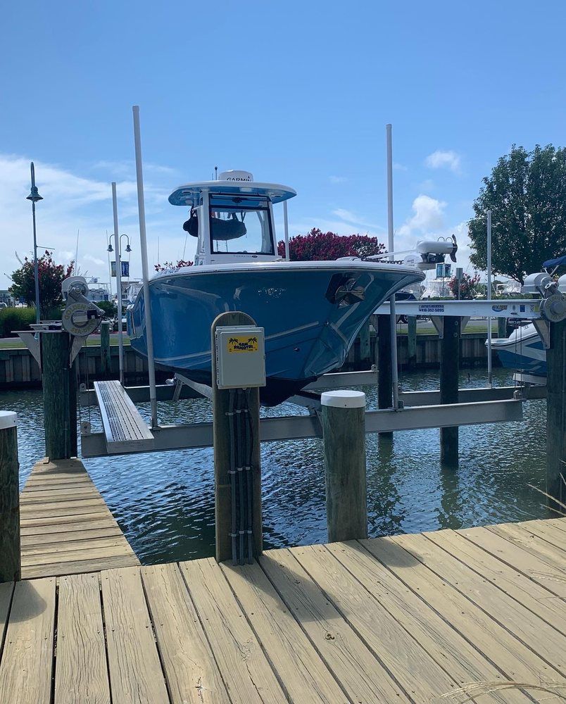 A blue boat is docked at a dock on a sunny day