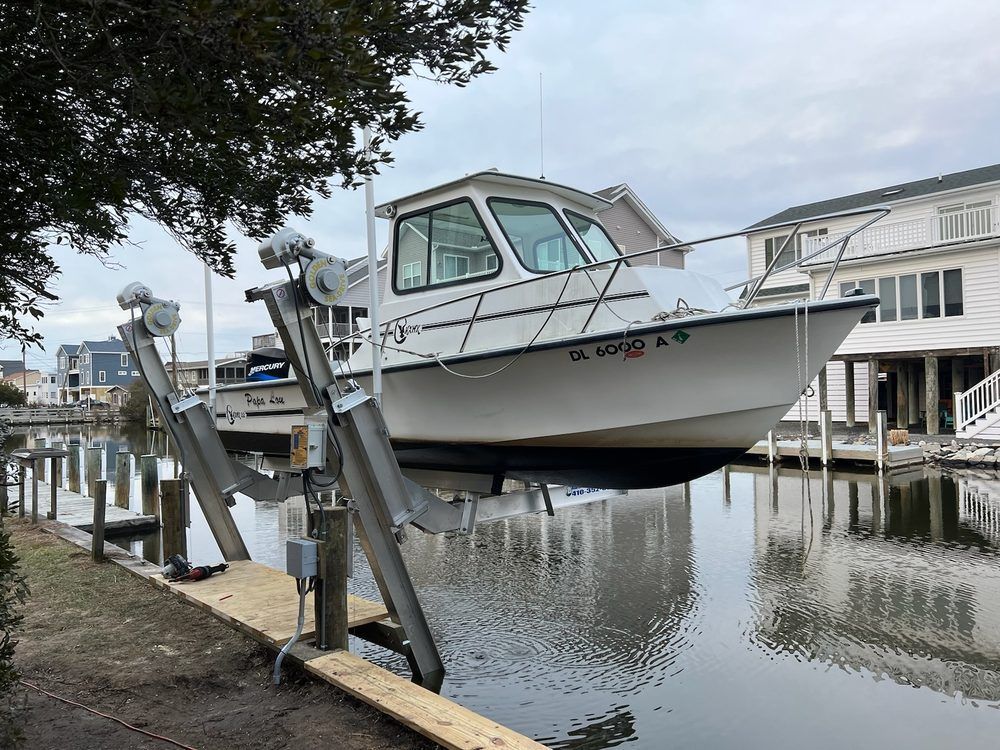 A boat is sitting on a lift in the water.
