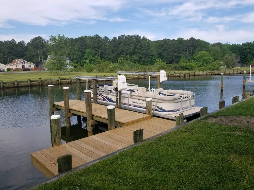 A pontoon boat is docked at a dock in the water.