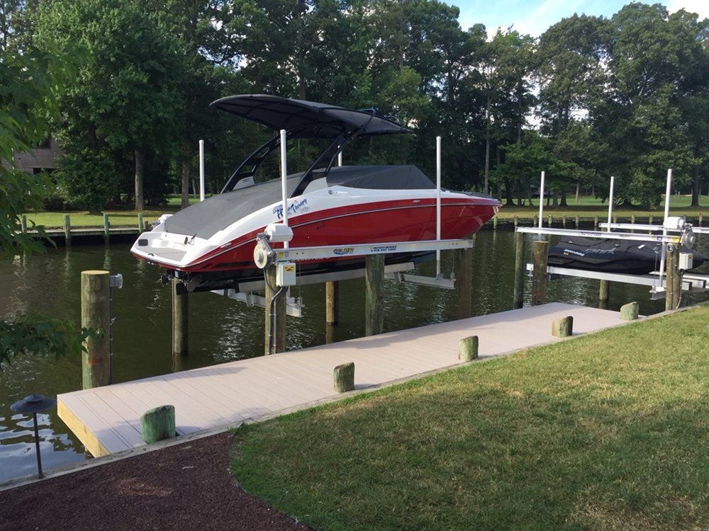A red and gray boat is docked at a dock