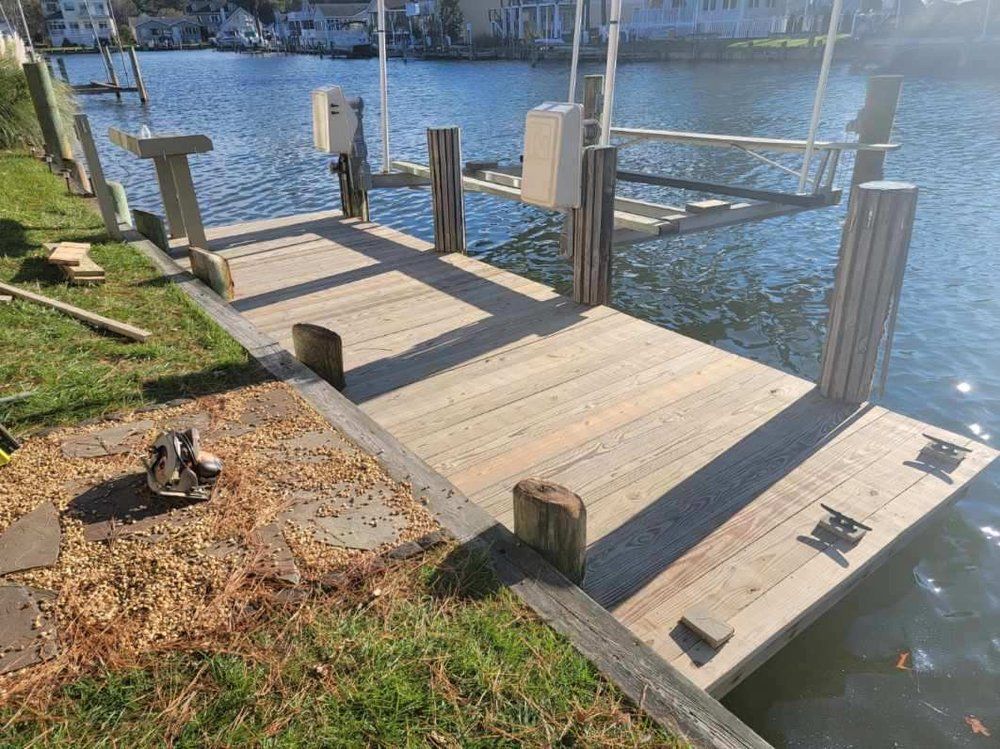 A wooden dock is sitting next to a body of water.