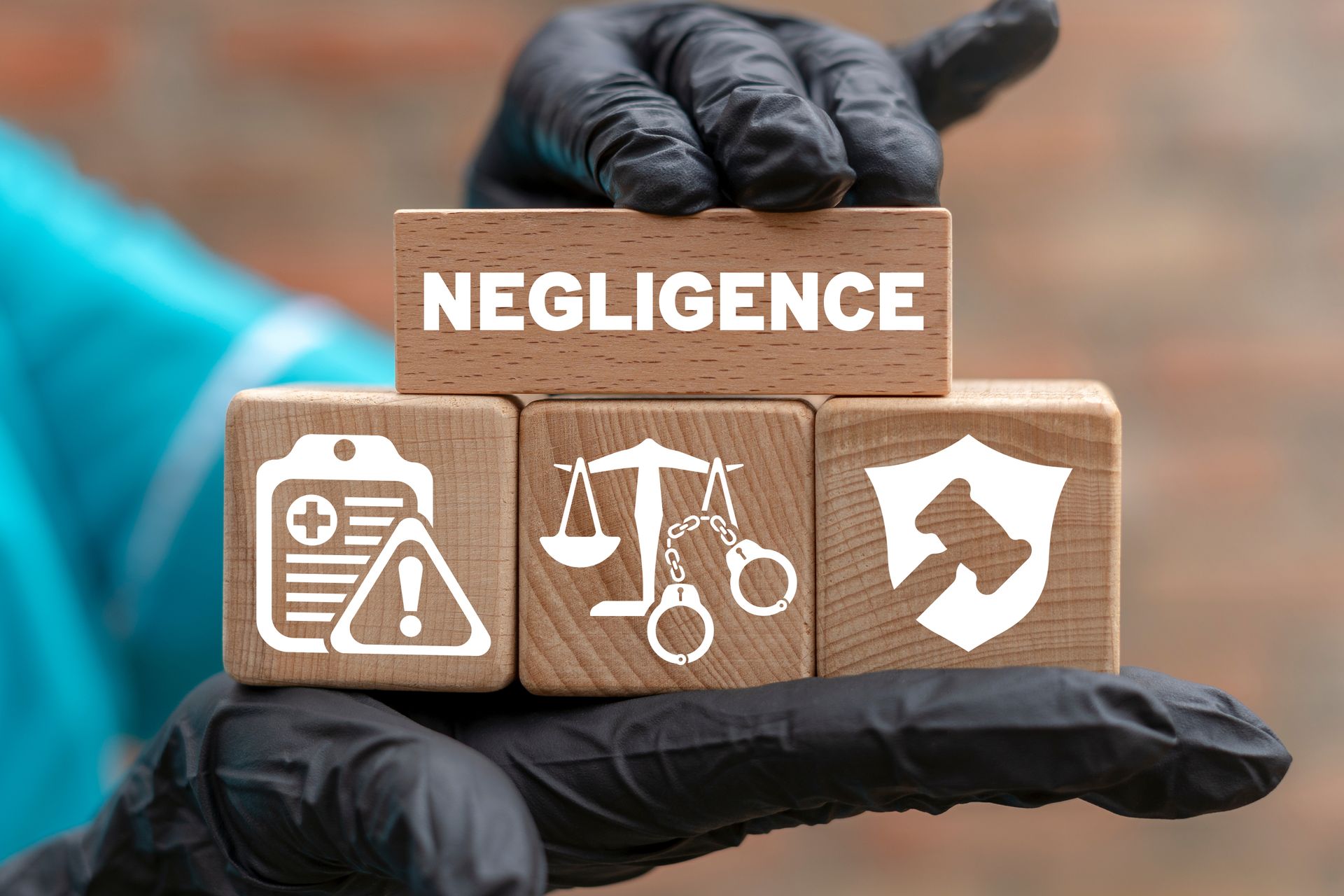 Wooden blocks with icons for healthcare, justice, and protection, topped with “NEGLIGENCE”.