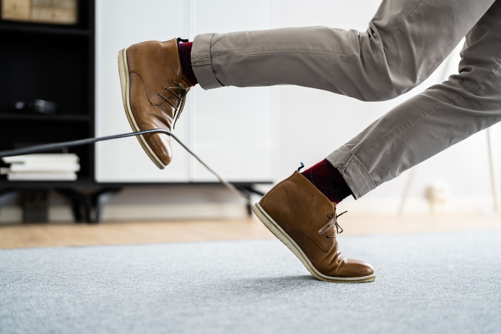 Person tripping over a wire cord, highlighting the need for a Slip and Fall Lawyer for accidents.