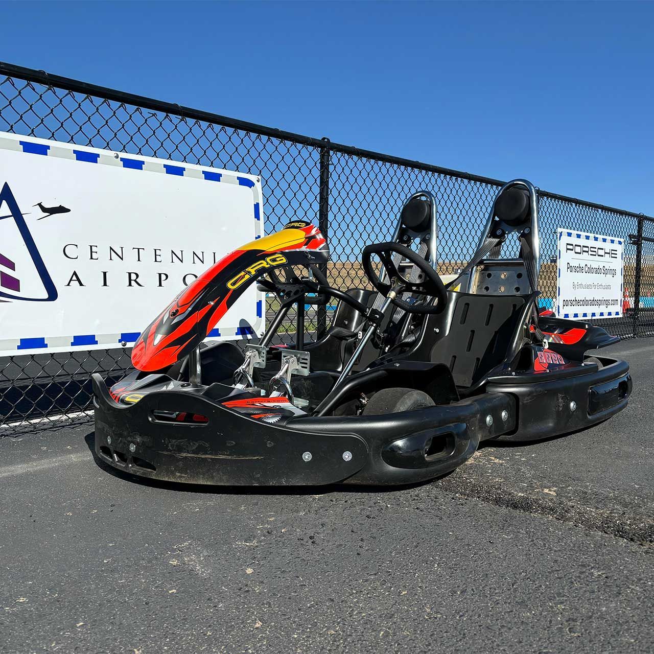 A man wearing a helmet sits on a go kart with the number 36 on it